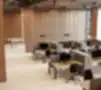 Erdvi modernaus biuro interjeras su ergonomiškomis darbo vietomis, privatumo panelėmis, medinėmis dekoratyvinėmis sienomis ir elegantišku pakabinamų lempų apšvietimu.