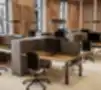 Modernios atviros biuro erdvės darbo vietos su ergonomiškais reguliuojamo aukščio stalais, privatumo panelėmis ir juodomis biuro kėdėmis po dekoratyvinėmis perforuotomis medinėmis sienų panelėmis.