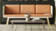 Moderni poilsio zona su oranžine minkšta sofa, tekstūriniu kilimu ir minimalistiniu kavos staliuku