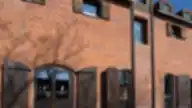 Michaelson Boutique Hotel pastato fasadas su raudonų plytų siena ir medinėmis langinėmis.