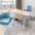 Modernus Nordclinic gydytojo kabinetas Kaune su mėlynomis kėdėmis, lenktu mediniu stalu ir miesto panorama pro langą.