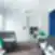 Wallter biuro dizainas, atviras ofiso planas, ergonominės žalios kėdės, balti darbo stalai, pilkos pertvaros, geltona akcentinė lempa, mėlynos užuolaidos ofise.