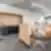 „Dematic“ biuro darbo vietos su medinėmis pertvaromis, ergonominėmis kėdėmis ir integruota virtuvėle.