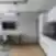Šiuolaikiškas Balcia Residence apartamentų interjeras su valgomojo stalu, virtuvės zona ir televizoriumi ant sienos.