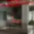 Emergn biuro poilsio ir kavos zona su baro tipo staliuku, oranžiniais akcentais ir žalumos elementais