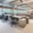 Modernus atviro plano biuras su ergonominėmis kėdėmis, bendrais darbo stalais ir natūralia šviesa – AmerisourceBergen - World Courier Lietuva
