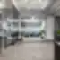 Modernaus coworking biuro erdvė su stiklinėmis pertvaromis, žaliosiomis sofos zonomis ir priekyje matoma „Workland“ registratūra.