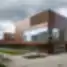 Modernus Rezeknės technologijų akademijos pastatas su stikliniais fasadais ir corten plieno apdaila.
