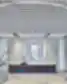 Deguonies Sistemos poilsio virtuvėlė su marmuriniu sala su integruota apvalia kriaukle, tamsaus medžio spintelėmis, prie sienos montuojamu kavos aparatu baltose spintelėse, apvaliu bendru stalu su mėlynomis sukamosiomis kėdėmis ir stikline vaza su gėlėmis, visa erdvė po atviru tinklelio lubų elementu ir apskritu LED žiedu. Pro stiklines pertvaras matyti susitikimų kambarys su permatomomis užuolaidomis.