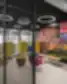 Moderni DHL Lietuva biuro neformali susitikimų zona: juoda metalinė pertvara, žemi mėlyni ir pilki foteliai, medinės spintelės su pavyzdiniais įmonės įrenginiais bei ryški miško motyvais dekoruota siena.