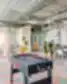 SHED Co-living Vilnius bendro naudojimo erdvė su stalo futbolu, poilsio zonomis, augalais ir spalvotomis grindų plytelėmis.