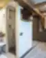 Viešbučio kambarys su atvira vonios zona, dušu ir medinėmis sijomis ant lubų.