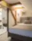 Michaelson Boutique Hotel mansardinis kambarys su medinėmis sijomis, dvigule lova ir atviru vonios kambariu.