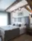Šviesus Michaelson Boutique Hotel kambarys su dvigule lova, medinėmis sijomis ir langais iki grindų.