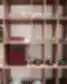 Medinės lentynos su stikliniais indais, žvakėmis ir dekoratyviniais puodeliais My Bibliotheque interjere.