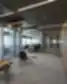 „Luminor“ biuro koridorius su stikliniais susitikimų kambariais ir moderniu apšvietimu.