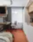 Modernus Balcia Residence kambarys su darbo zona, televizoriumi ir virtuvės spintele.