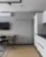 Šiuolaikiškas Balcia Residence apartamentų interjeras su valgomojo stalu, virtuvės zona ir televizoriumi ant sienos.
