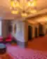 Grand Poet Hotel by Semarah viešbučio koridorius su ryškiu raštuotu kilimu, šiuolaikiškais šviestuvais ir poilsio zona prie lango.