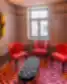 Poilsio zona Grand Poet Hotel by Semarah koridoriuje su trimis raudonomis kėdėmis ir minkštu pufu šalia lango.