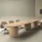 Long Eleva conference table with a wooden tabletop and meeting chairs in a modern meeting room.
