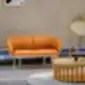 Oranžinė Grace sofa modernioje svetainėje su apvaliu mediniu kavos staliuku.
