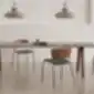 Tamsios medienos ARC kėdės su paminkštinimu prie ilgo stalo.