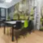 Fondo juodos ir žalios kėdės iš NowyStyl valgomojo erdvėje su miško sienų freska.