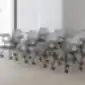 Varya XL konferencijų kėdės Inclass su ratukais ir rašymo lentelėmis, sustatytos posėdžių salėje.